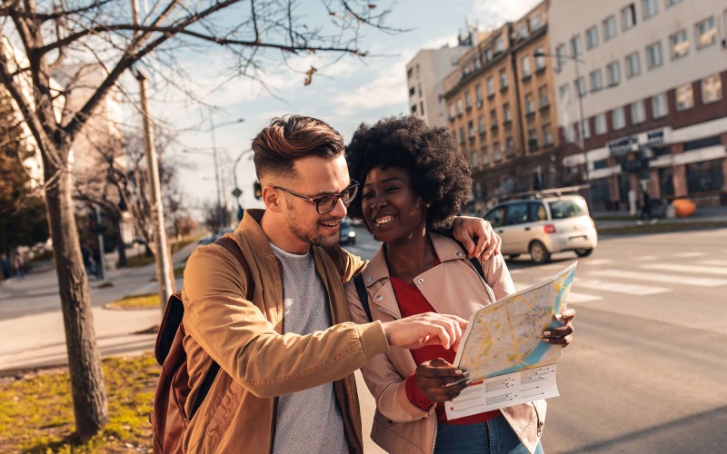 a man and woman looking at a map in the city